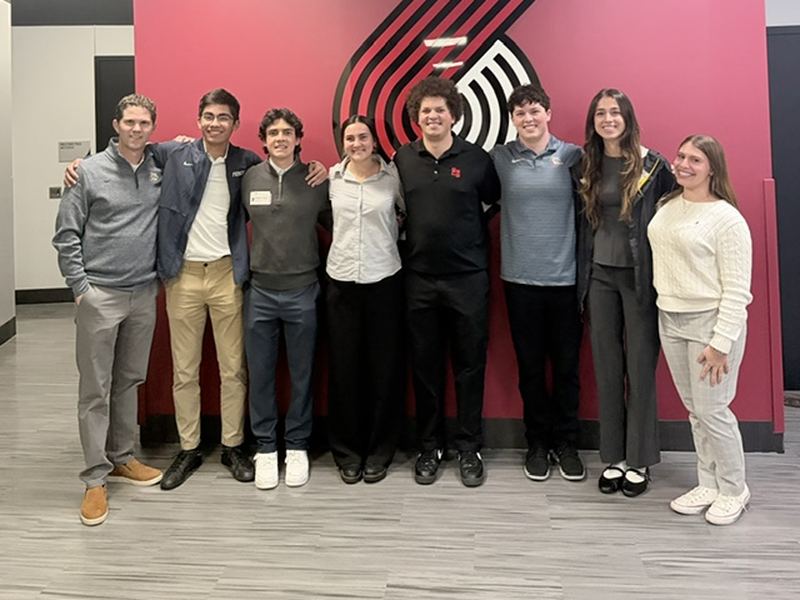 Students in front of the Portland Trail Blazers logo wall.