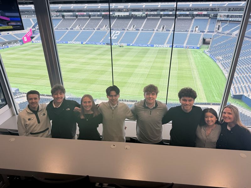 Students in a suite overlooking the pitch at Lumen Field.